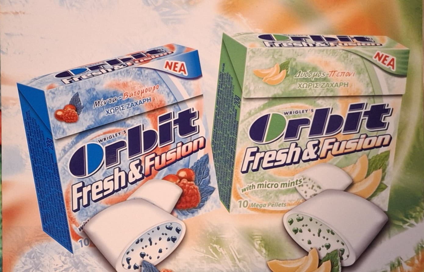 Two boxes of Orbit Fresh & Fusion gum featuring raspberry and melon flavors, Greek packaging.